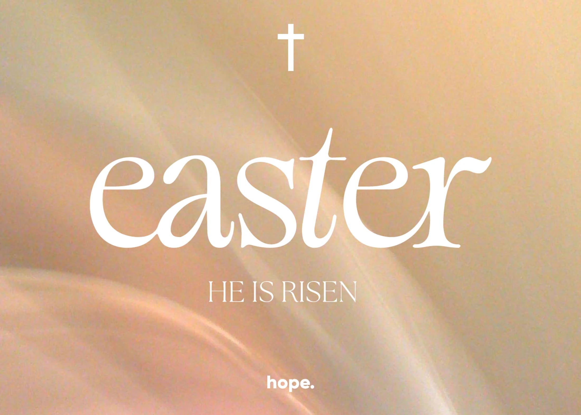A graphic with a soft, glowing gold background. White text reads 'Easter' and 'He Is Risen' with a cross symbol above and the word 'hope' below.